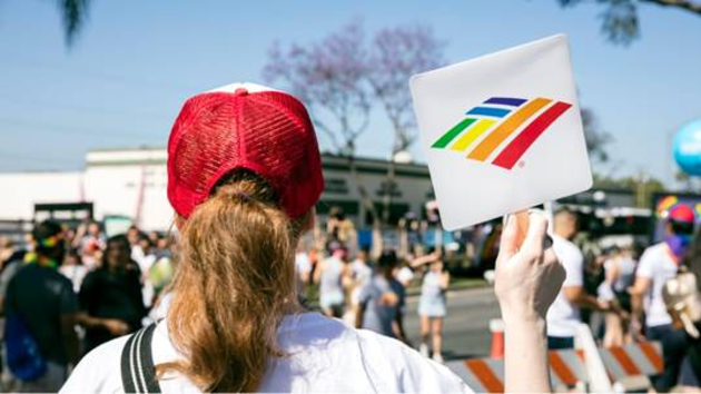 Woman holding Bank of America Pride flag at Pride Parade